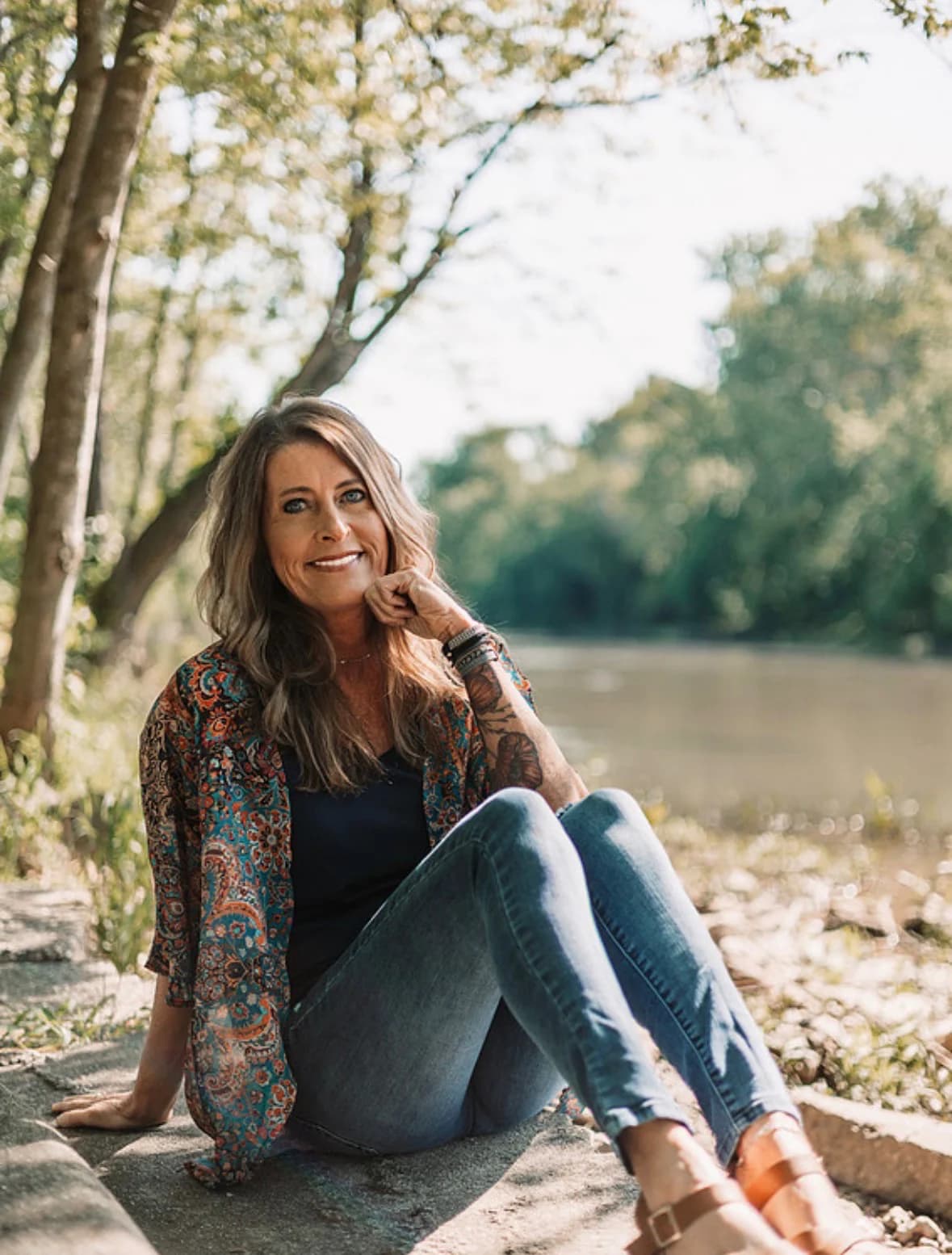 Kandace Cain seated outdoors by a river
